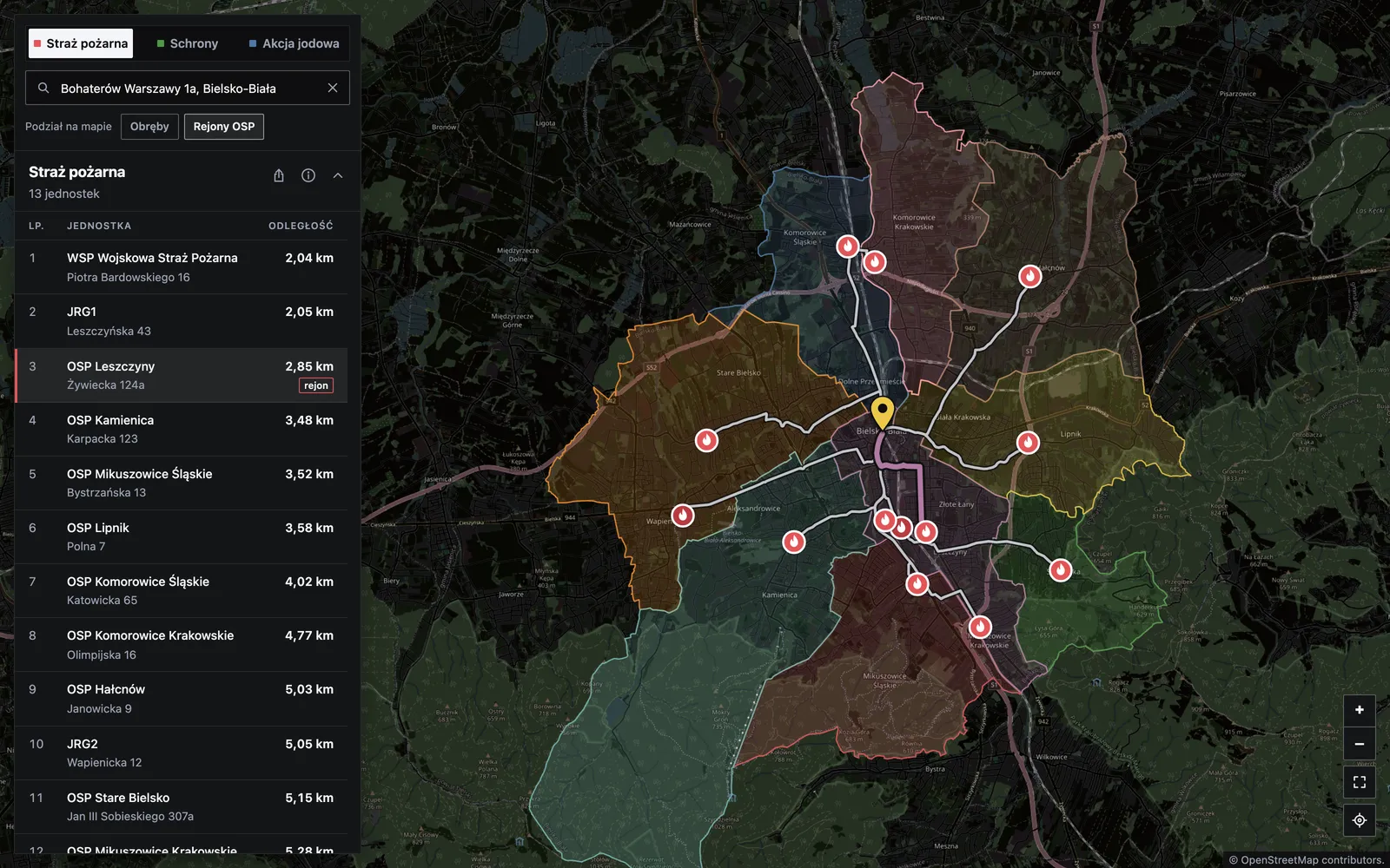 Mapa Bezpieczne Bielsko-Biała w zakładce Straż pożarna: wybrany punkt w mieście, kolorowe rejony OSP, narysowane trasy do jednostek i lista jednostek po lewej stronie.